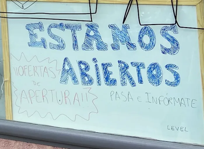 Pizarra blanca con «Estamos abiertos, pasa e infórmate»
